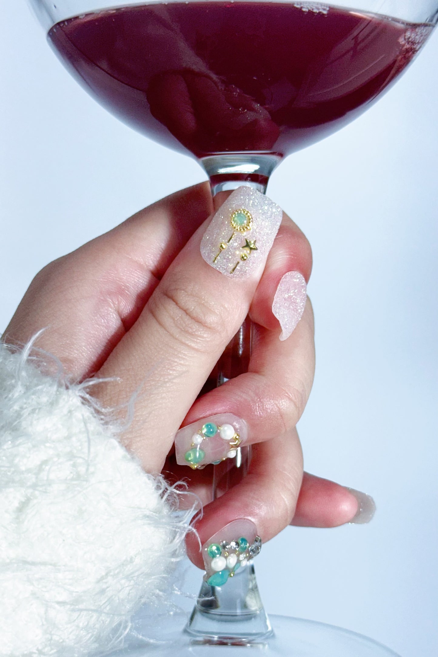 Snowy Christmas press-on nail holding a red wine glass