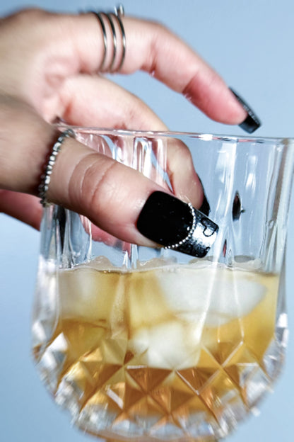 Chic Noir press-on nail, holding a glass with whisky